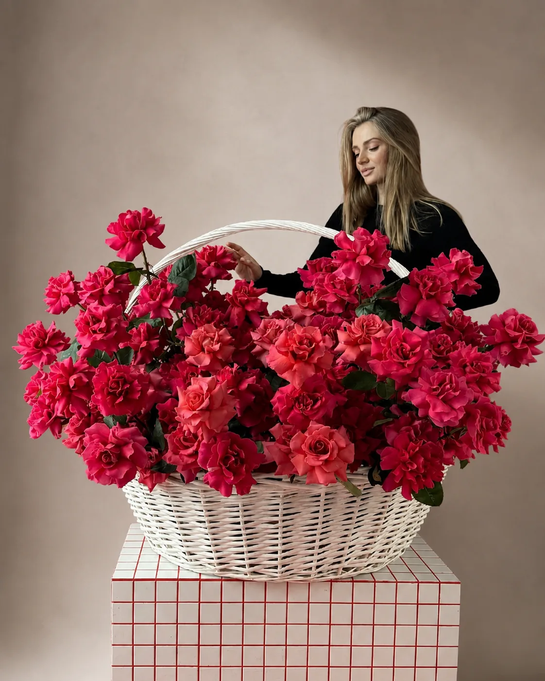 A hand-tied bouquet of 50 red and cream roses on a marble table in a sunlit Dubai apartment, with city skyline visible through the windows.